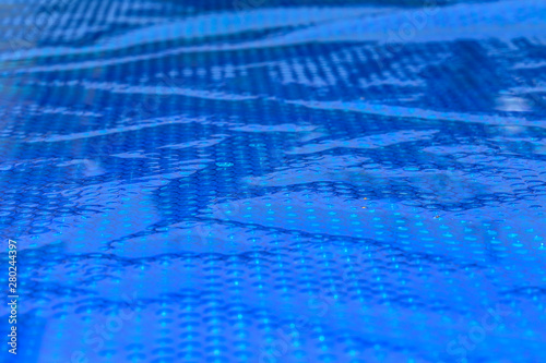 Blue cyan abstract background. Close up of blue bubble plastic used as a swimming pool insulation cover to prevent evaporation of water and to retain the heat
