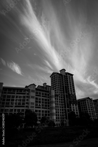 Cloud formations in the background of a residential area in black and white