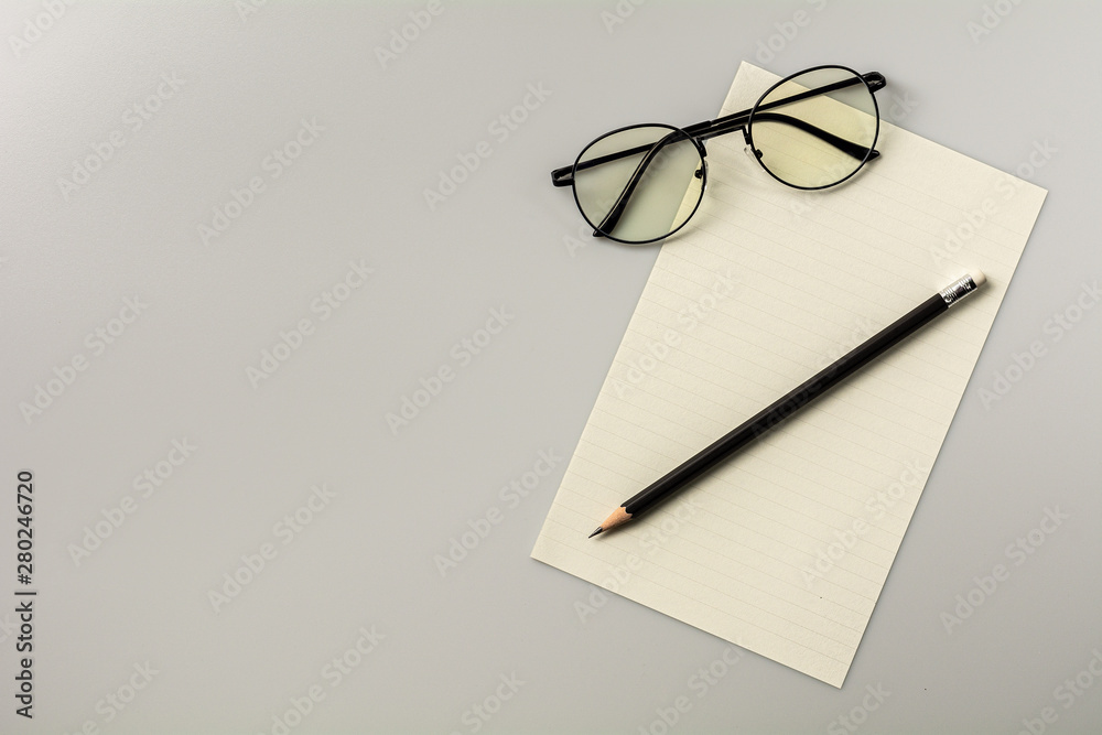 blank note paper and a pencil on grey desk background. blank note paper and a pencil on grey desk background.