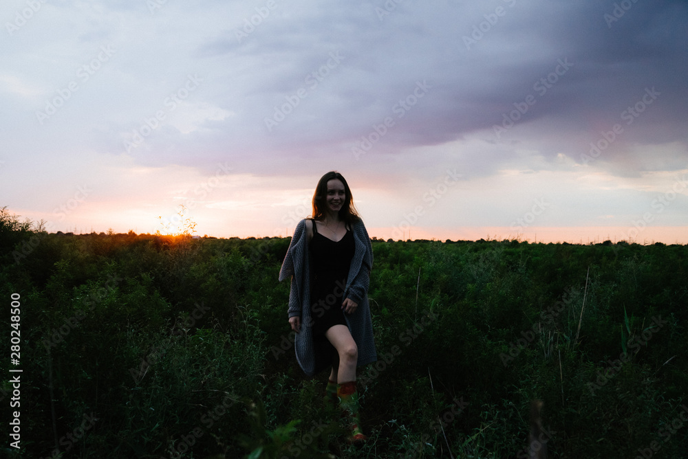 Woman enjoying nature in meadow. Outstretched arms fresh morning air summer Field at sunrise.