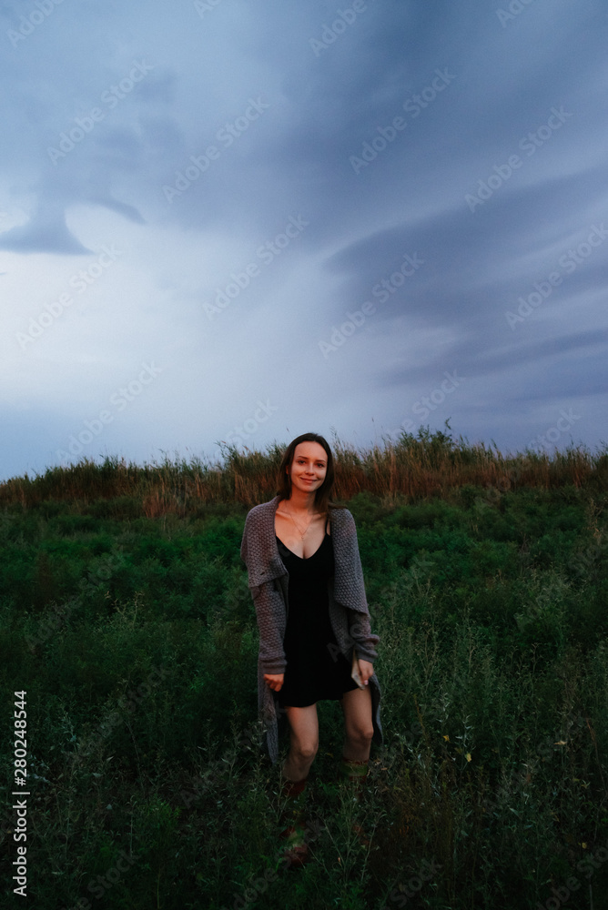 Woman enjoying nature in meadow. Outstretched arms fresh morning air summer Field at sunrise.