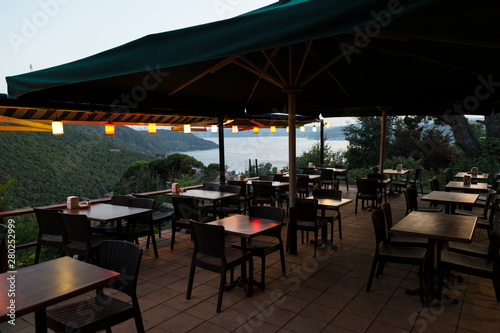 the authentic restaurant with beautiful sea view from Istanbul. the wooden table and chairs in the cafe. © Fertas