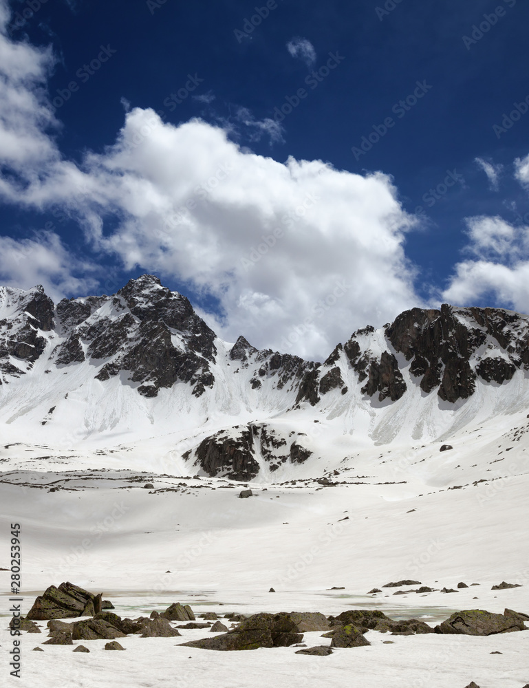 Obraz premium Plateau in mountains with frozen lake covered snow and blue cloudy sky
