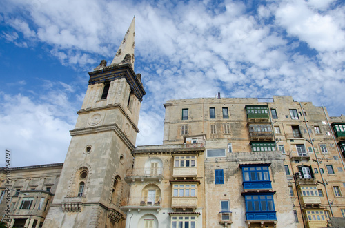 Facade of the house with yellow, blue and green maltese balconies in Valletta in Malta