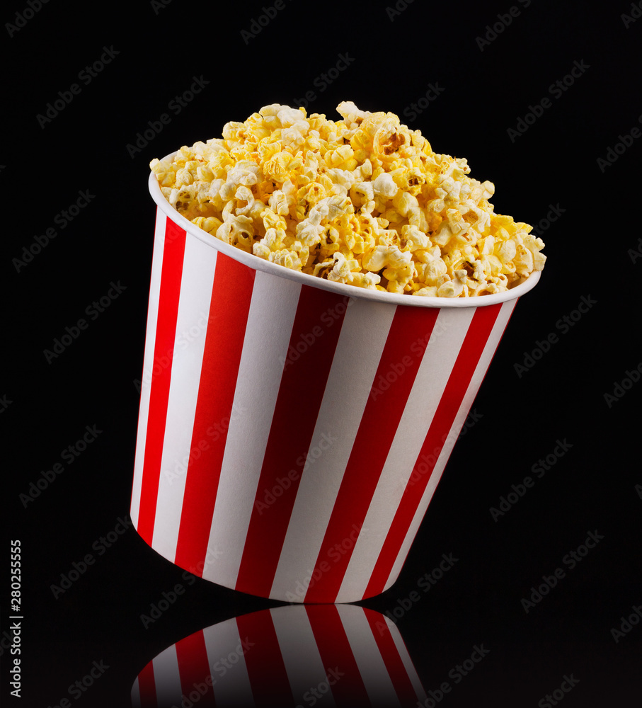 Paper striped bucket with popcorn isolated on black background Paper striped bucket with popcorn isolated on black background
