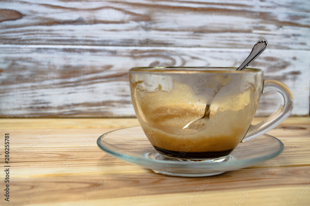 empty cup of espresso and a silver coffee spoon on a wooden table close up empty cup of espresso and a silver coffee spoon on a wooden table close up
