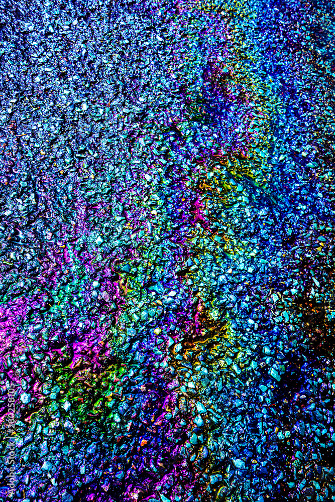 Obraz premium A leaked Car Oil Petrol in The Rain on a Tarmac Road Metallic Rainbow