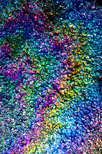 A leaked Car Oil Petrol in The Rain on a Tarmac Road Metallic Rainbow