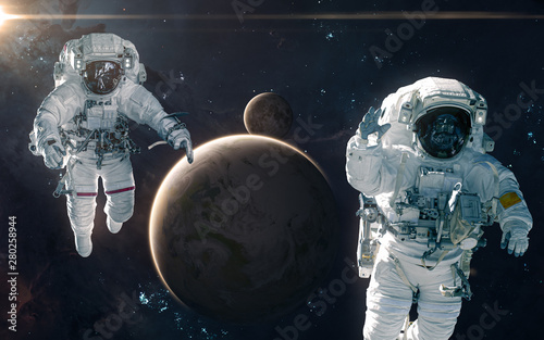 Fototapeta Naklejka Na Ścianę i Meble -  Two astronauts on background of Earth and Moon. Solar system. Science fiction. Elements of this image furnished by NASA