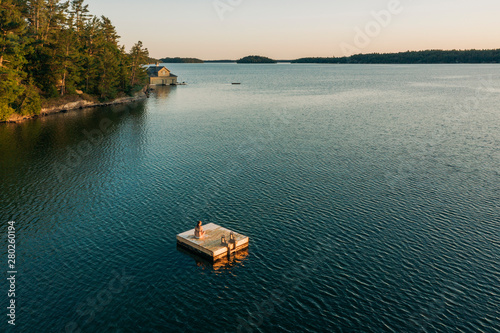 Woman Sitting On Floating Dock In Canadian Lake photo