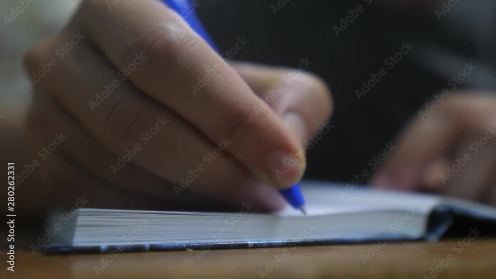man writes in notebook. man's hand writing in a notepad. concept business lifestyle education. man makes notes in notebook that lies on the table man writes in notebook. man's hand writing in a notepad. concept business lifestyle education. man makes notes in notebook that lies on the table