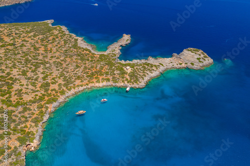 Aerial drone view of traditional Greek wooden boats floating on the crystal clear waters of the Aegean Sea (Crete)