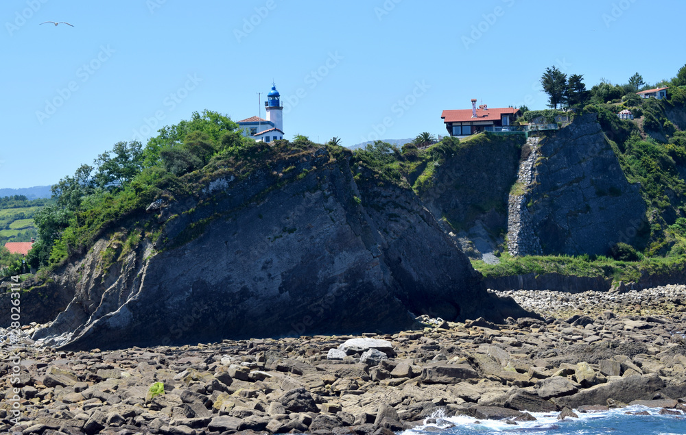 Faro blanco y azul en lo alto de un acantilado. Faro blanco y azul en lo alto de un acantilado.