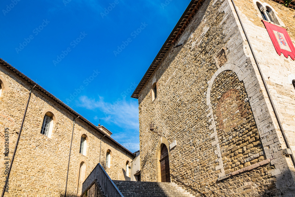 The ancient Palazzo dei Consoli in the medieval village of Bevagna. Perugia, Umbria, Italy. The staircase, the brick and stone wall and the mullioned windows.