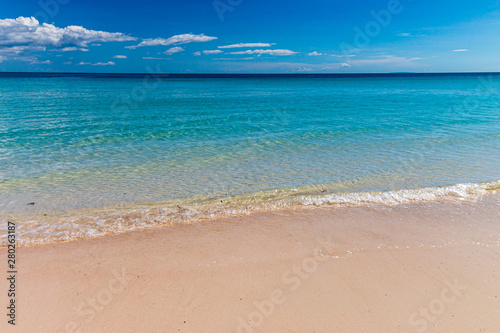 Fototapeta Naklejka Na Ścianę i Meble -  Gentle ocean waves lapping onto a sandy, tropical beach.  Relaxing background.