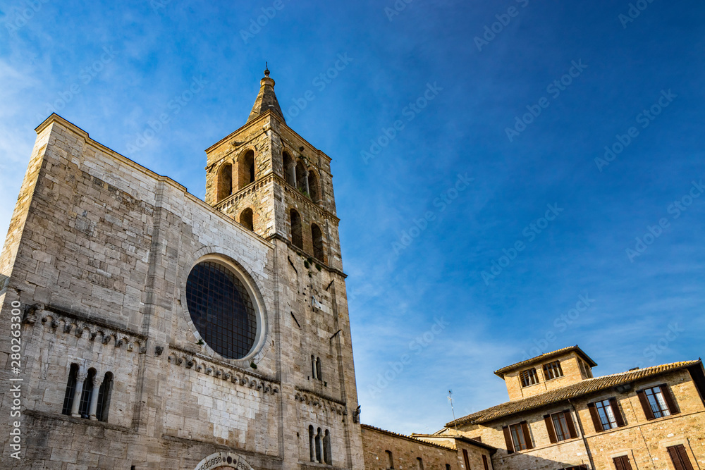 The Romanesque Church of San Michele in the medieval village of Bevagna. Perugia, Umbria, Italy. The travertine facade, with the large rose window and the Gothic bell tower.