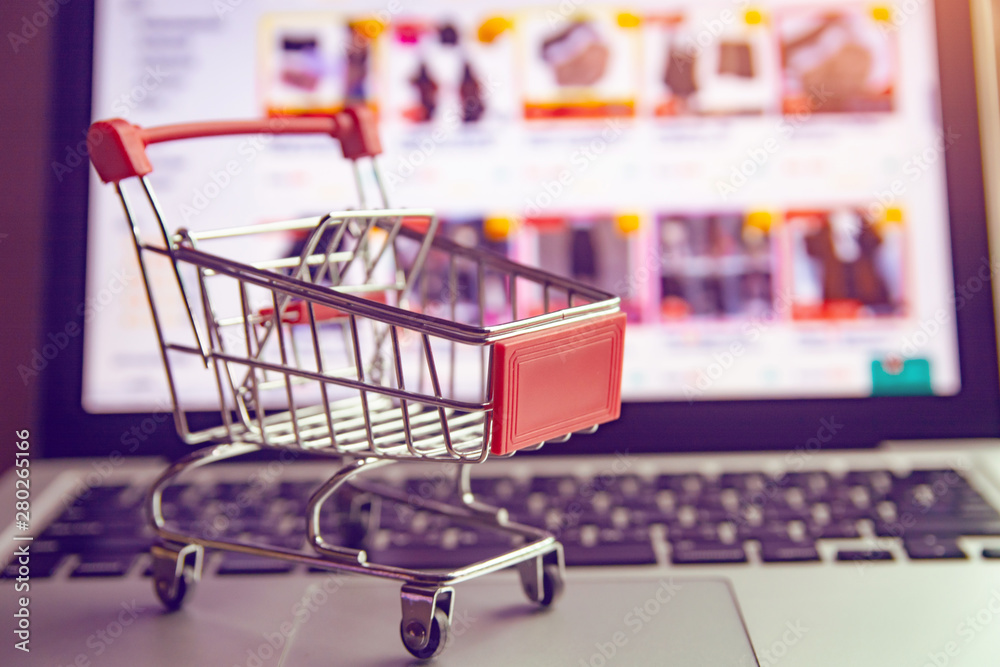 Shopping online concept - shopping cart or trolley on a laptop keyboard. Shopping service on The online web.