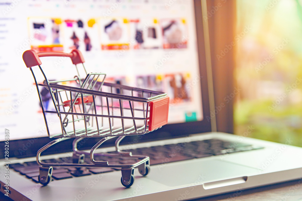 Shopping online concept - shopping cart or trolley on a laptop keyboard. Shopping service on The online web.