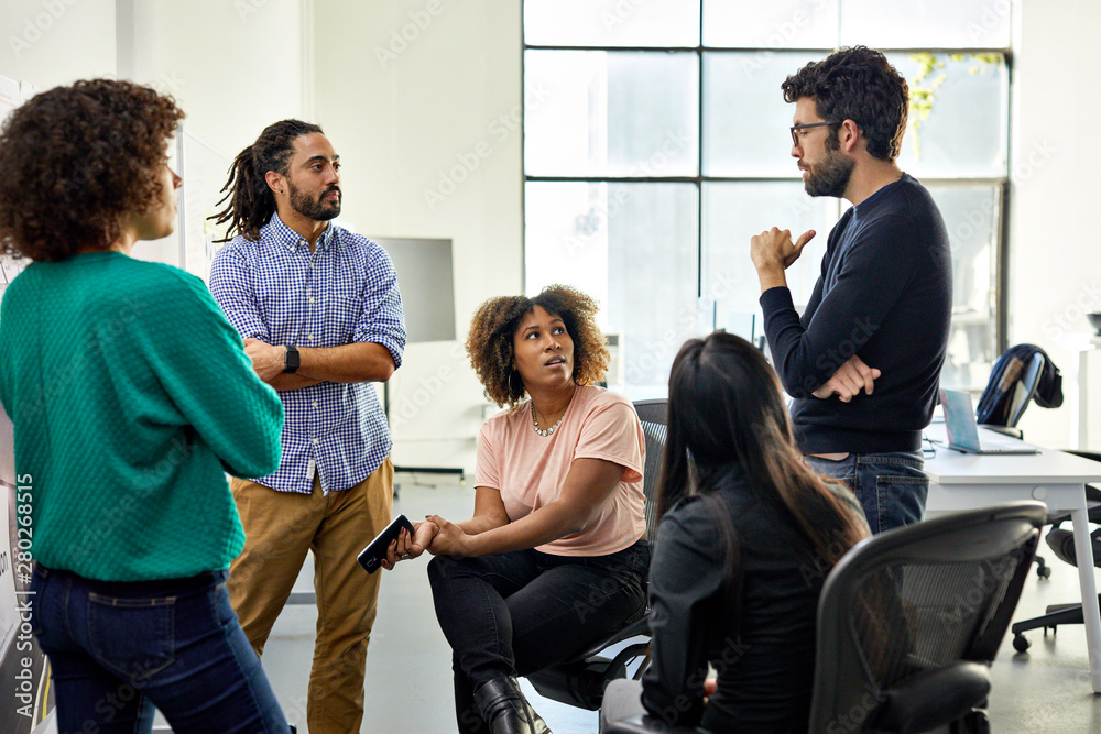 Businessman explaining to colleagues in meeting at office Businessman explaining to colleagues in meeting at office