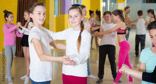 Teenagers dancing waltz in pairs in studio