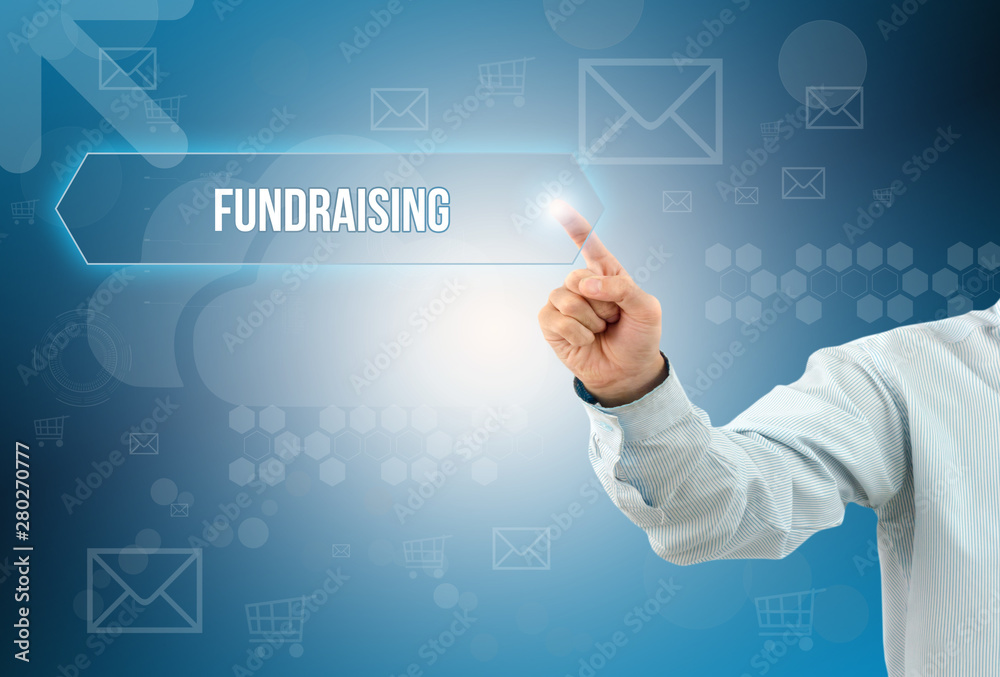 Obraz premium business man touch a button on an imaginary screen with text FUNDRAISING