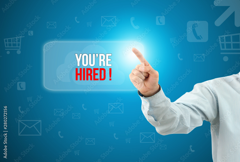 Business man touch a button on an imaginary screen with text YOU'RE HIRED Business man touch a button on an imaginary screen with text YOU'RE HIRED