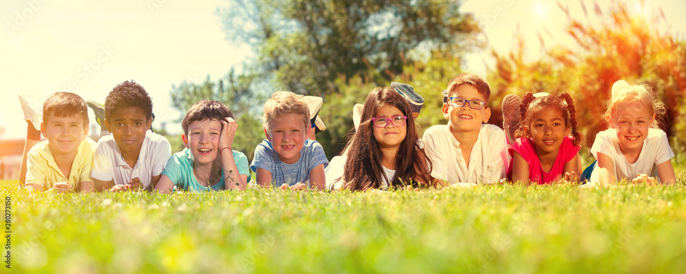 © JackF - Team of friends children resting on grass together in park © JackF - Team of friends children resting on grass together in park