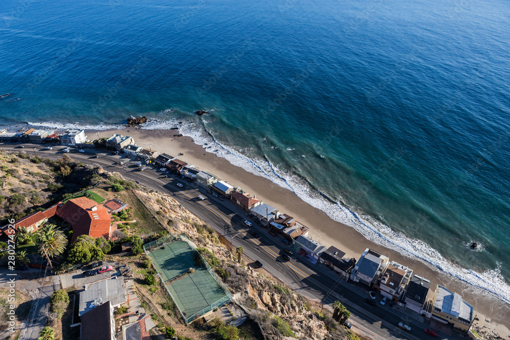 Aerial of beach homes along and above Pacific Coast Highway near Los Angeles in scenic Malibu California.  
