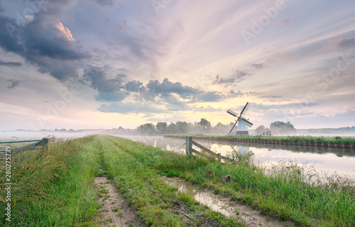 beautiful morning over charming windmill by river