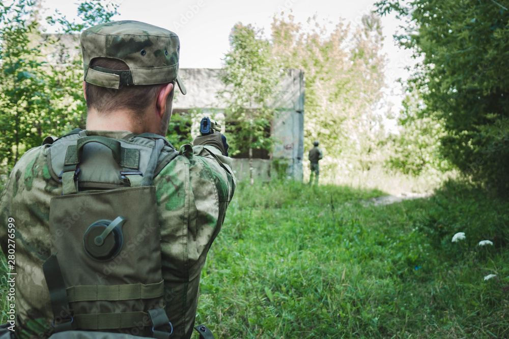 Fototapeta premium military in the form of aiming and trying to shoot a gun. rear view