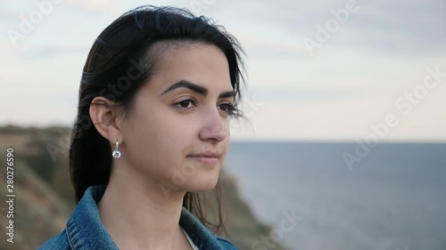 Stylish brunette girl waiting for her he-man on a seacoast at sunset in slo-mo 
