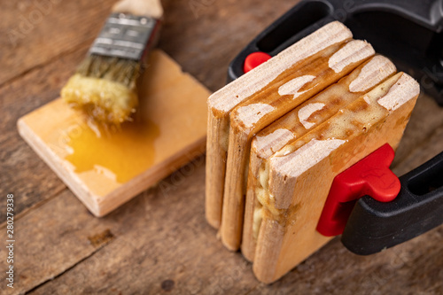 Gluing wood with waterproof adhesive. Pieces of wood pressed together with carpentry clamps.