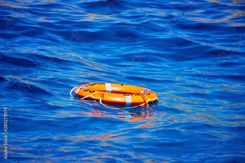 Glowing sunny warm waves of Cyprus with orange life-buoy