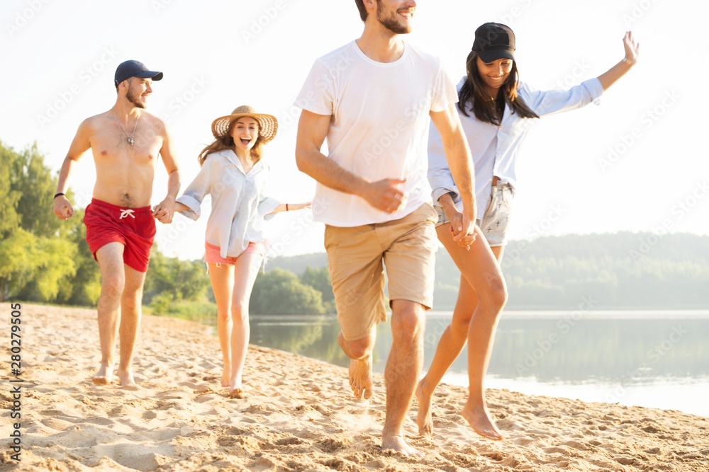 Group of friends having fun running down the beach Group of friends having fun running down the beach