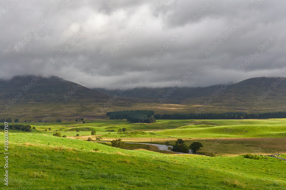 The Valley Floor of Glen Clova looking East with dark clouds threatening stormy weather on one Summers morning in August. Angus, Scotland.