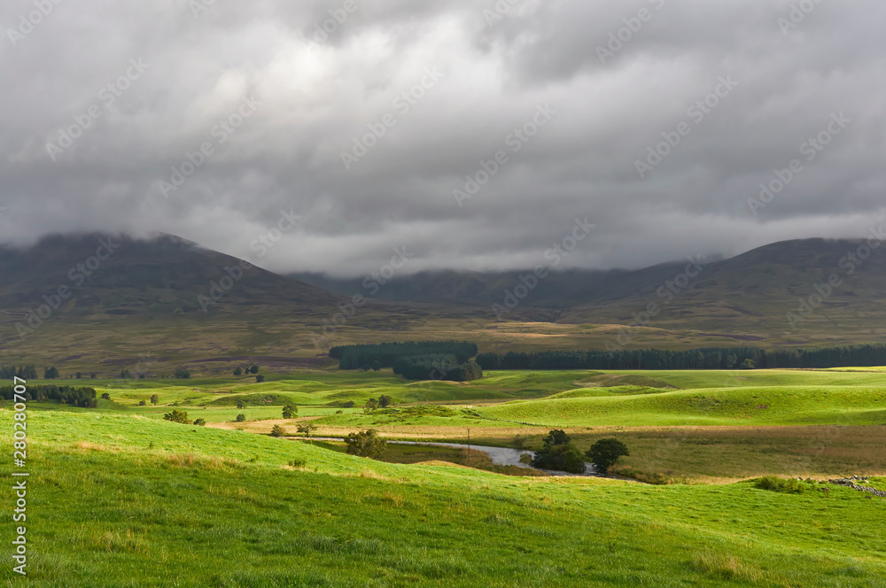 The Valley Floor of Glen Clova looking East with dark clouds threatening stormy weather on one Summers morning in August. Angus, Scotland. The Valley Floor of Glen Clova looking East with dark clouds threatening stormy weather on one Summers morning in August. Angus, Scotland.