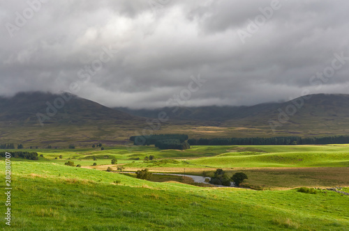 The Valley Floor of Glen Clova looking East with dark clouds threatening stormy weather on one Summers morning in August. Angus, Scotland.