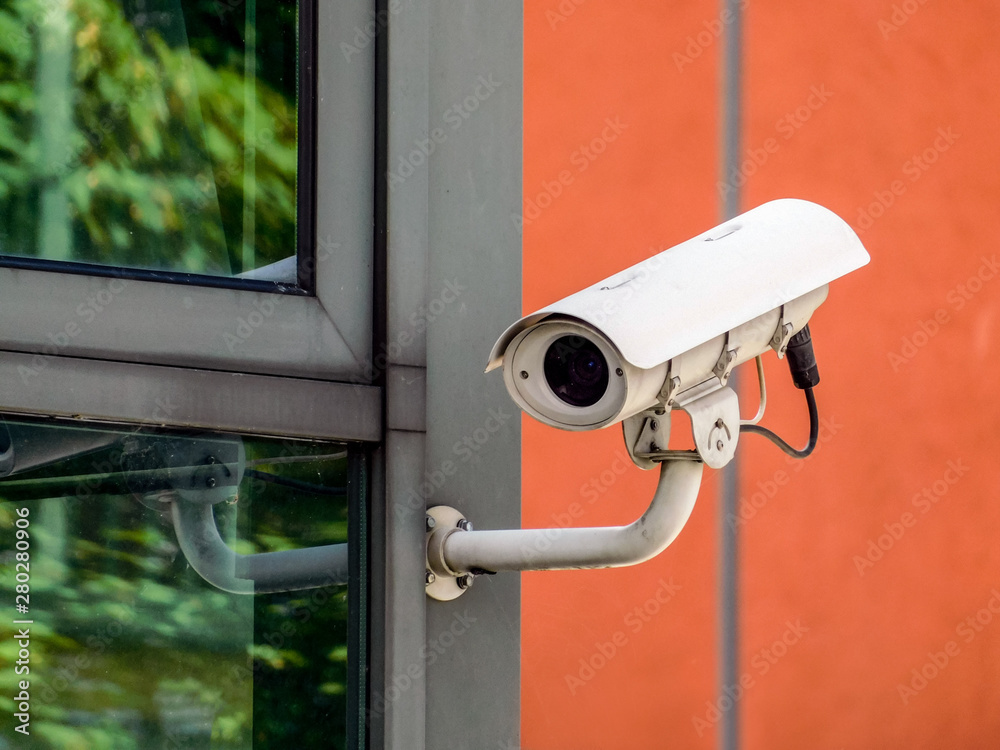 White CCTV security camera monitoring everything around the building White CCTV security camera monitoring everything around the building