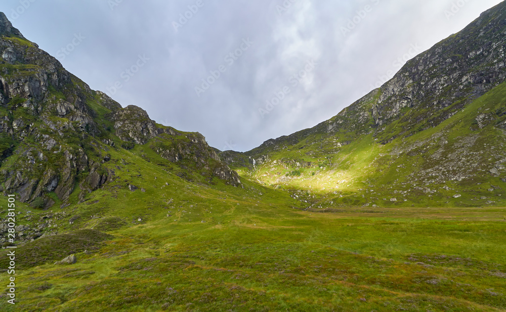 The Early morning Sun begins to break through the Cloud layer and light up the Valley sides of Corrie Fee in the Angus Glens of Scotland.