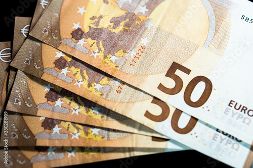 Stack of Euro banknotes (€) on dark background - Closeup on 50 EURO banknots.