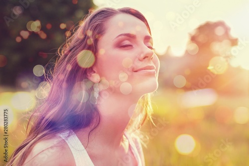 Young woman on field under sunset light