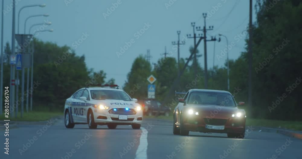 High speed police pursuit on highway. View of cop patrol car chasing a thief on red modern car driving away from the law.