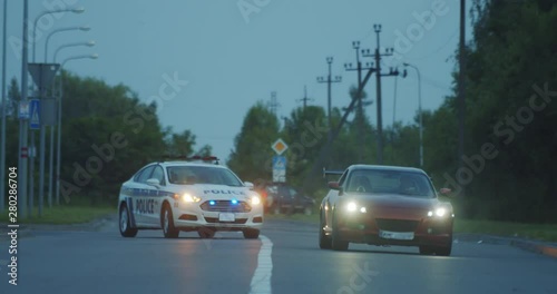 High speed police pursuit on highway. View of cop patrol car chasing a thief on red modern car driving away from the law.