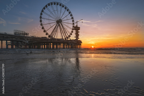 Landscape of a sunset at the beach and the pier of Scheveningen with nobody, no tourists, The Hague, Netherlands