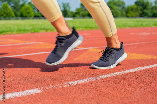 Close-up feet of woman on track, runner on running lane