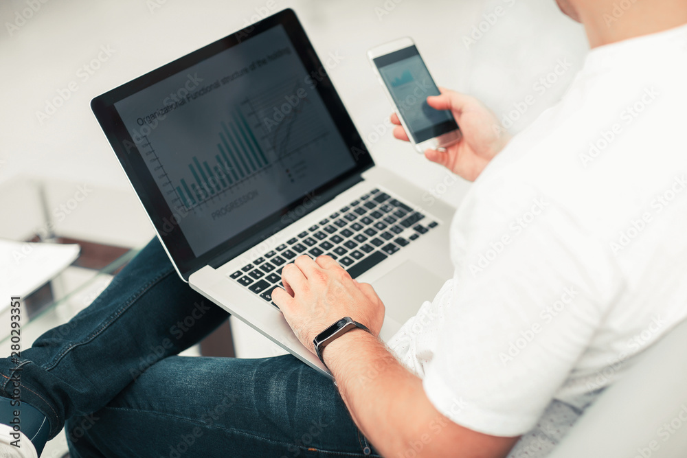 close up. businessman using smartphone and laptop close up. businessman using smartphone and laptop
