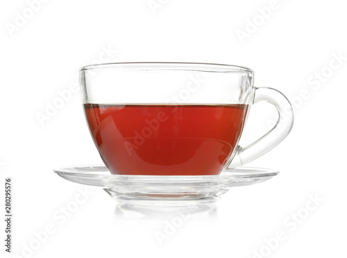 Glass cup of tea and saucer on white background