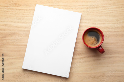 Blank paper sheets for brochure and cup of coffee on wooden background, flat lay. Mock up