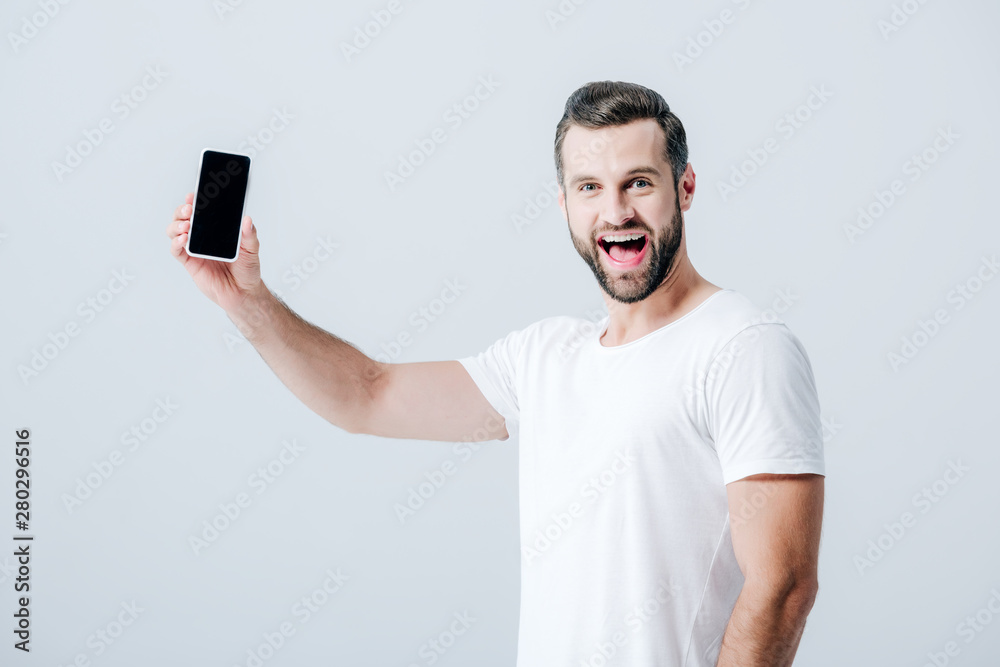 cheerful man showing smartphone with blank screen isolated on grey cheerful man showing smartphone with blank screen isolated on grey