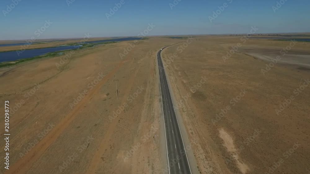 Aerial view on empty road in the desert or field in the middle of nowhere. Cinematic footage of 2 lanes motorway. Aerial view on empty road in the desert or field in the middle of nowhere. Cinematic footage of 2 lanes motorway.